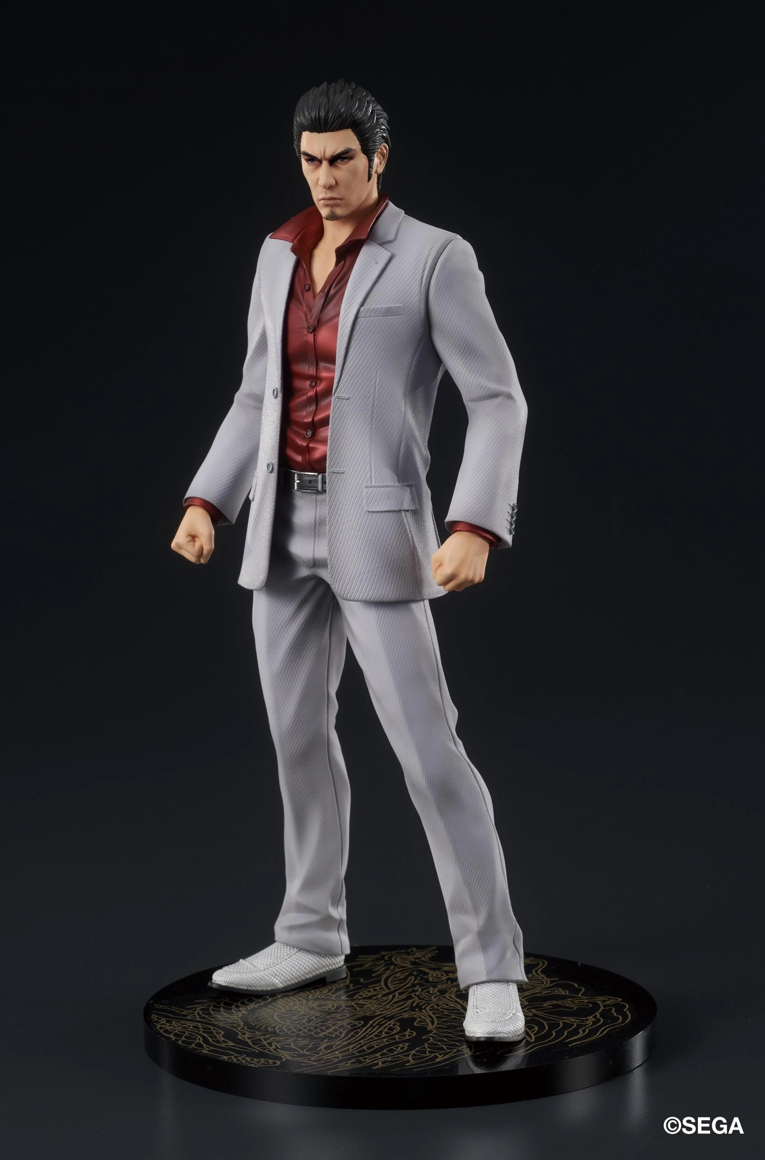 A three-quarter front view of the Kazuma Kiryu figure, showcasing his determined expression and the sharp tailoring of his gray suit.
