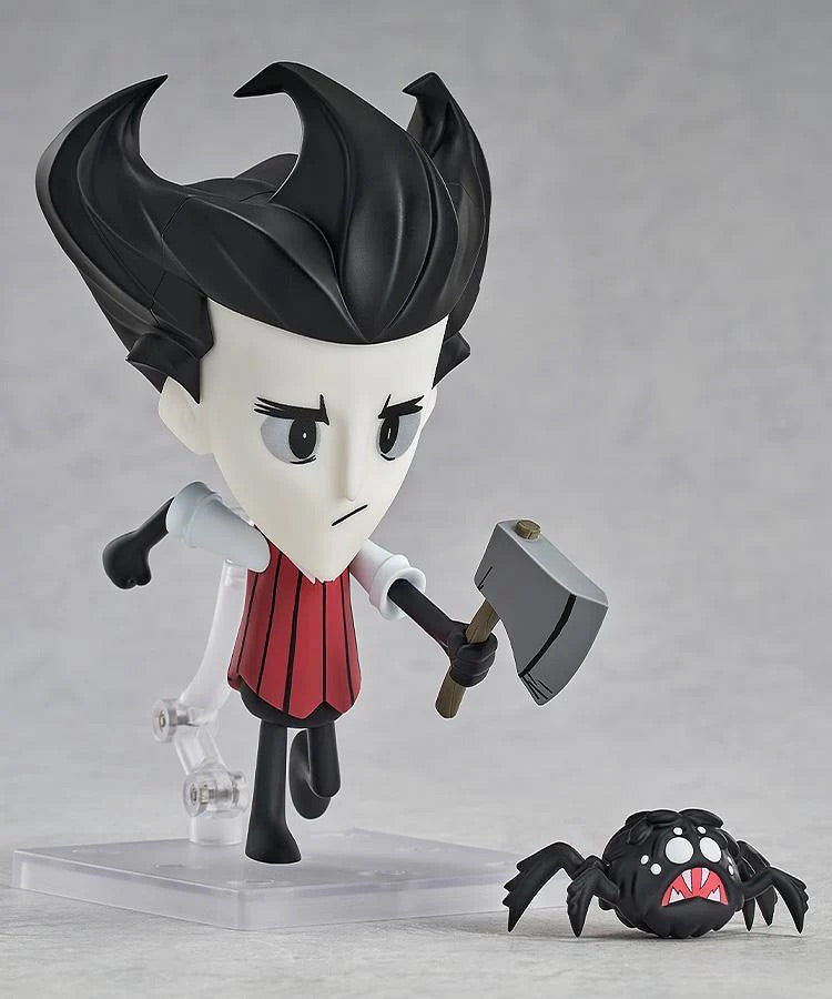 Nendoroid Wilson figure posed holding the axe, standing next to the small, dark spider enemy accessory.