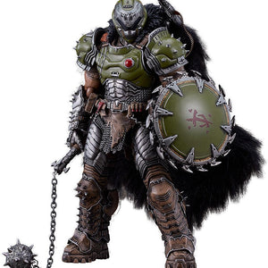 Front product view of the Doom: The Dark Ages Doom Slayer figma DX Edition figure, showcasing his heavy green armor, fur cape, chain shield, and the deluxe flail weapon resting on the ground.