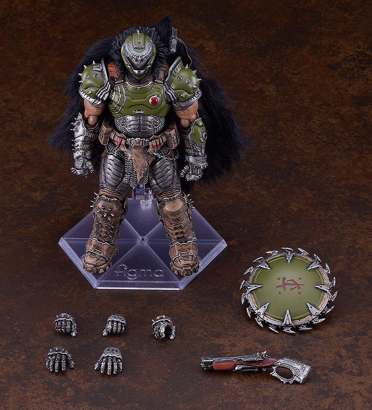 Overhead studio layout of the figma Doom Slayer figure alongside its complete accessories, including five interchangeable hands, the super shotgun, and the circular chain shield.