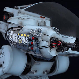 Macro shot of the ED-209's right arm weapon system featuring detailed missiles, gun barrels, and exposed wiring.
