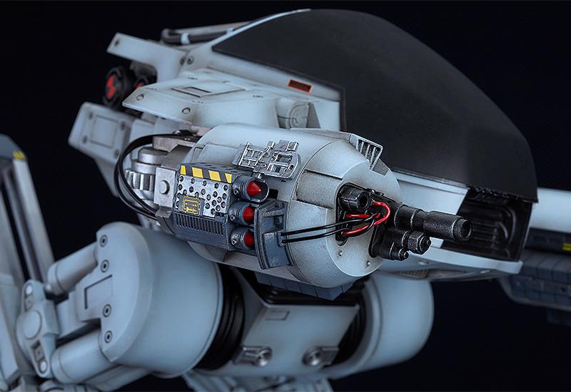 Macro shot of the ED-209's right arm weapon system featuring detailed missiles, gun barrels, and exposed wiring.