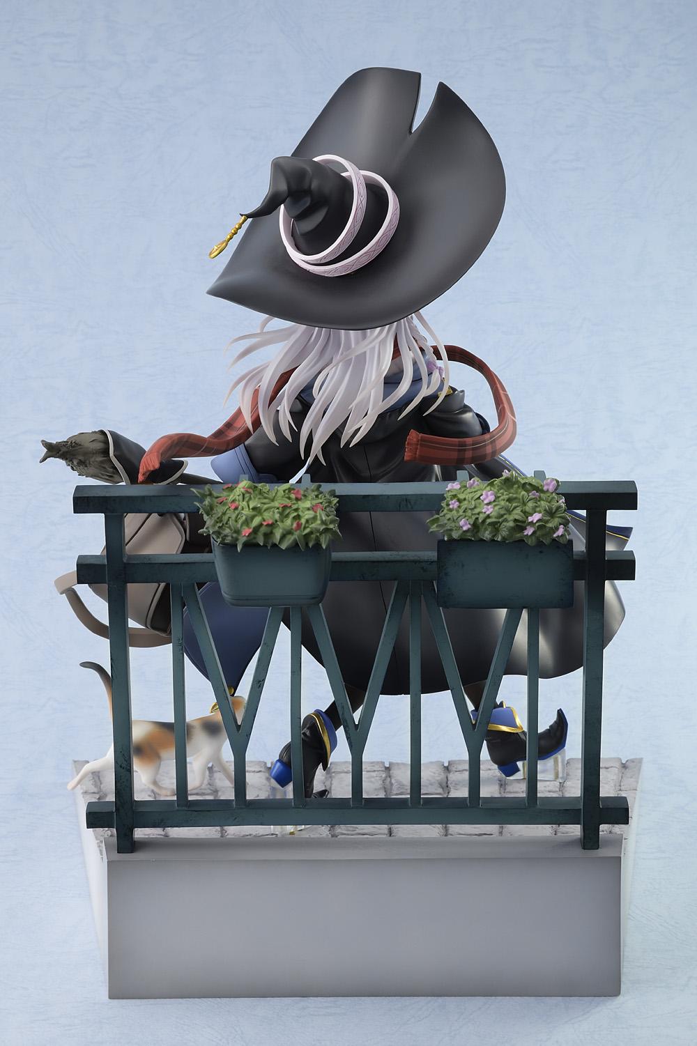 Rear view of the Elaina witch figure highlighting her long flowing silver hair, black pointed hat, and the vignette balcony railing base decorated with flower planters.