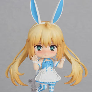 Close-up of Nendoroid Altria Caster's upper body with the blushing face, posed as if waving or greeting, highlighting the blonde hair and blue bows.