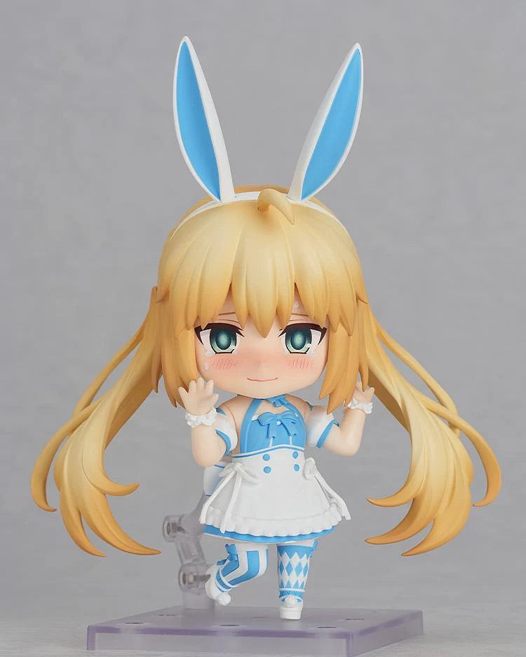 Close-up of Nendoroid Altria Caster's upper body with the blushing face, posed as if waving or greeting, highlighting the blonde hair and blue bows.