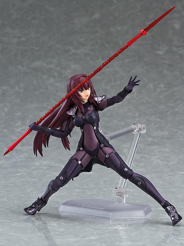 Low-angle dynamic lunging pose of the Fate/Grand Order Scathach figma figure wielding a long red lance overhead with a shouting combat expression.