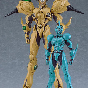 Size comparison of the figma Guyver Gigantic standing next to the Guyver I figma on a solid grey studio background.