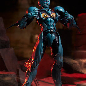 figma Guyver I in a power-up pose with open chest armor amidst rubble and red atmospheric lighting.