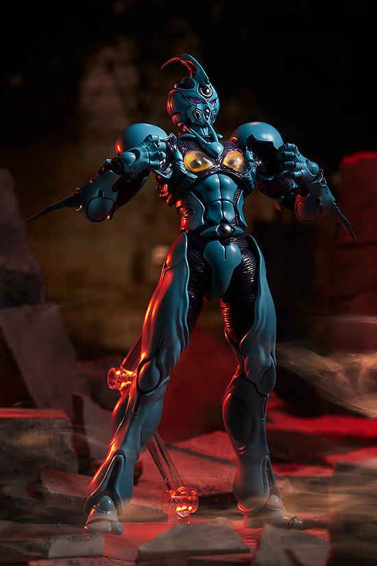 figma Guyver I in a power-up pose with open chest armor amidst rubble and red atmospheric lighting.
