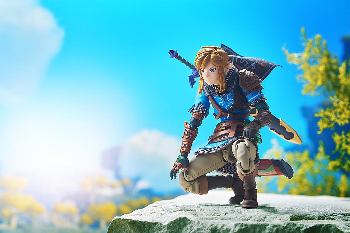 Cinematic shot of figma Link kneeling on a rock wearing the Hylian Hood against a bright sky background.