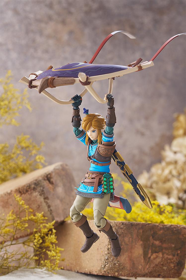 Link figma figure dynamically posed in mid-air holding the Paraglider accessory from Tears of the Kingdom.