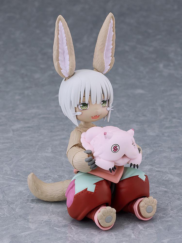 Seated figma Nanachi figure without her hat, gently holding the small pink Mitty figure in her lap.