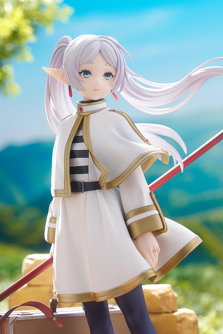 Promotional lifestyle image of Frieren the mage standing in a lush green meadow under a blue sky.