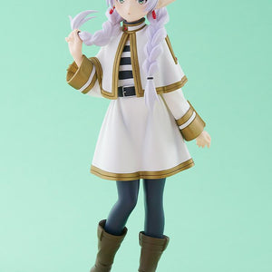 Full-body studio shot of the Frieren elf mage anime figure standing on a clear round base against a solid light green background.