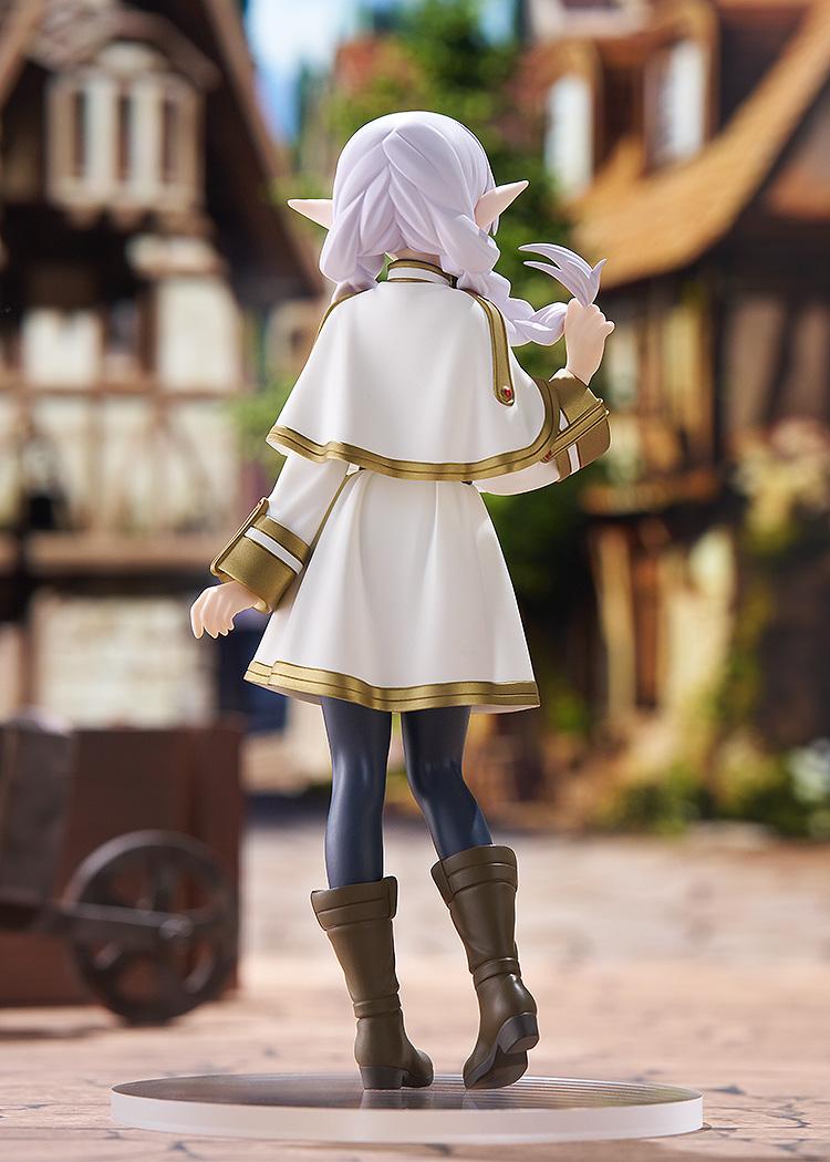 Back view of the Frieren POP UP PARADE figure in a scenic outdoor village diorama, emphasizing the flow of her capelet and hair.