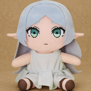 Studio shot of the 6.7-inch Frieren Apprentice Era plush sitting against a neutral tan background, showing embroidered green eyes and soft polyester texture.