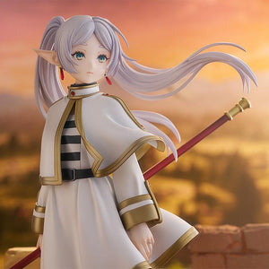 Promotional visual of Frieren scale figure bathed in the golden light of a setting sun.