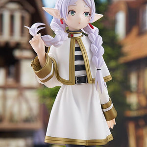 Medium portrait shot of the Frieren Braids version figure looking toward the horizon, seamlessly integrated into a scenic anime-style village environment.
