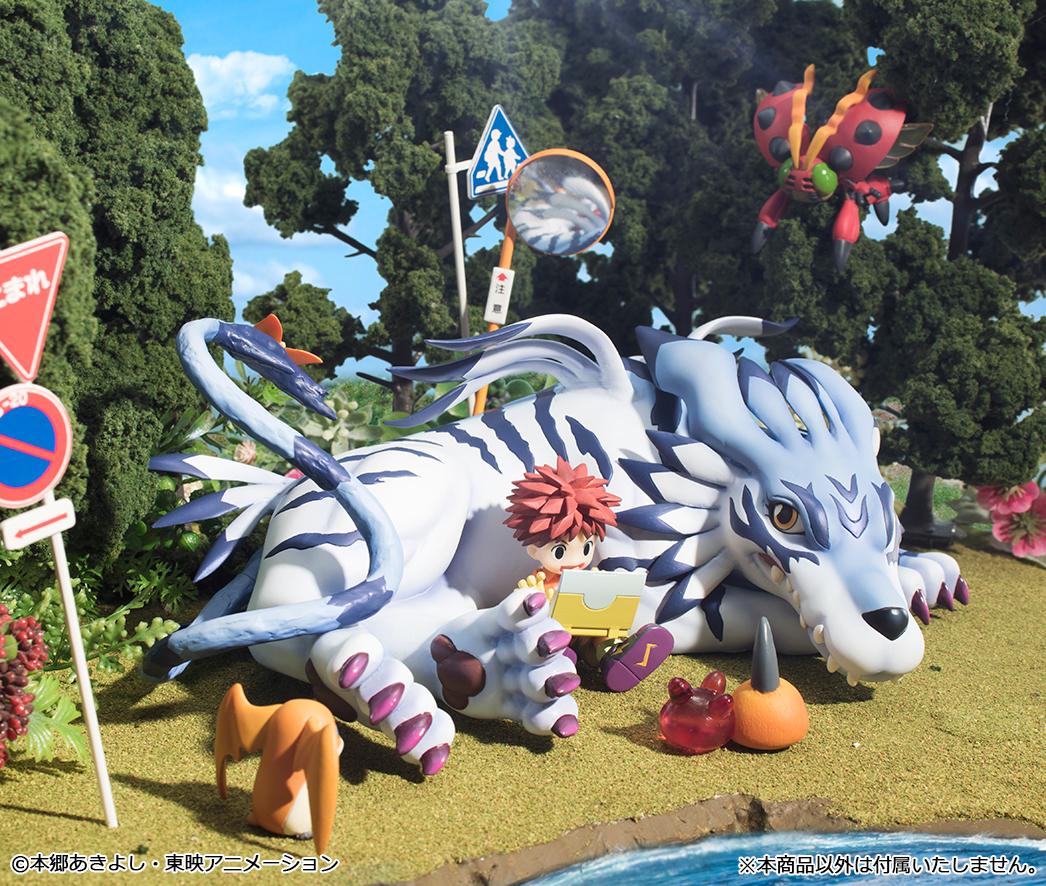 Outdoor nature diorama display showing G.E.M. Garurumon resting in a grassy landscape alongside Digimon Adventure companion figures.
