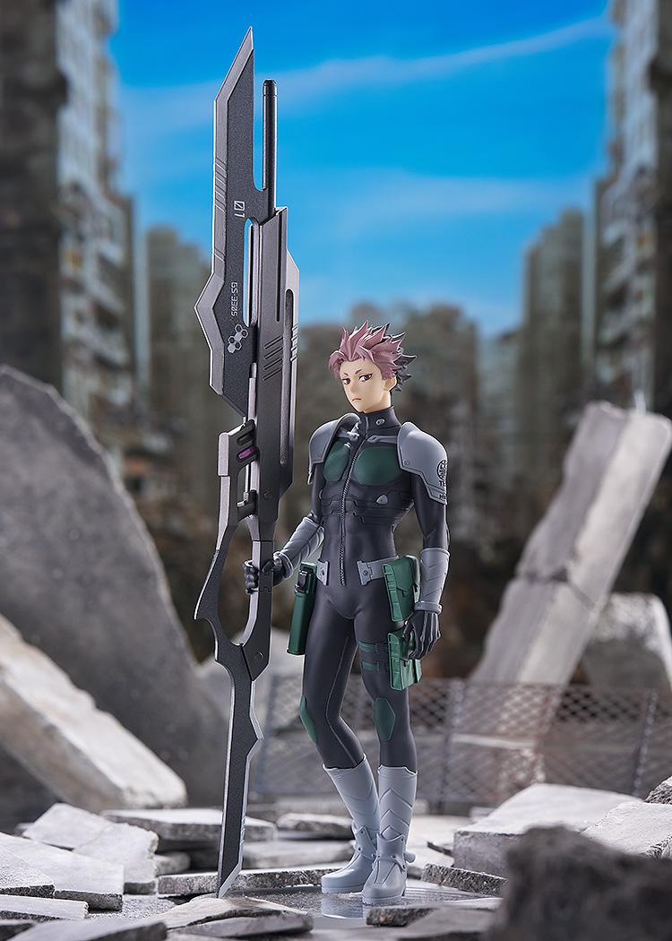 Full-body diorama display of the Gen Narumi Pop Up Parade figure standing amidst concrete rubble in a ruined post-apocalyptic city backdrop.