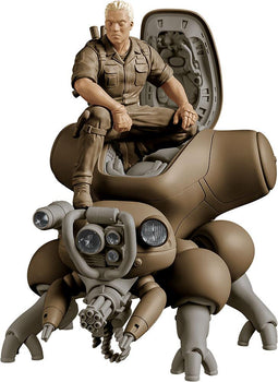 Close-up studio product shot of the 1/20 scale PLAMAX Batou figure with cybernetic eyes sitting in the open cockpit hatch of a khaki-brown Fuchikoma spider tank against a white background.