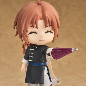 Cheerful pose of the Kamui Nendoroid figure pointing a closed purple umbrella forward with his grinning face plate attached.