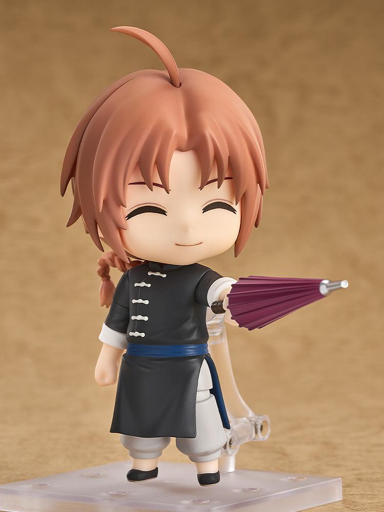 Cheerful pose of the Kamui Nendoroid figure pointing a closed purple umbrella forward with his grinning face plate attached.