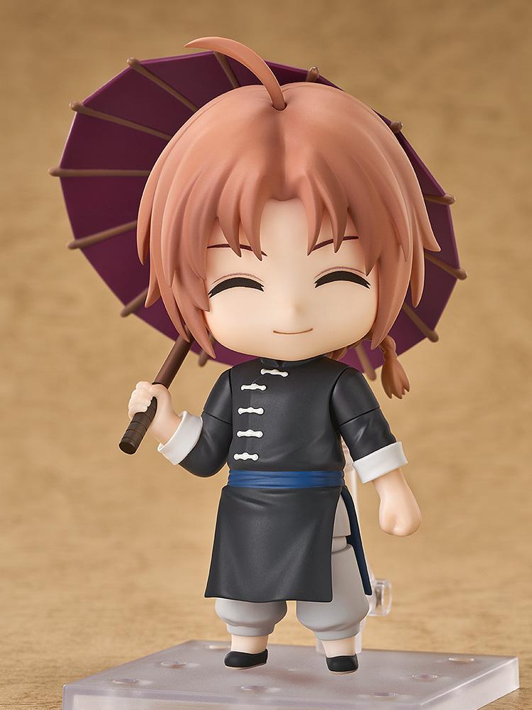 Full-body studio display of the Kamui Nendoroid figure from Gintama featuring his grinning face plate and holding an open purple umbrella.