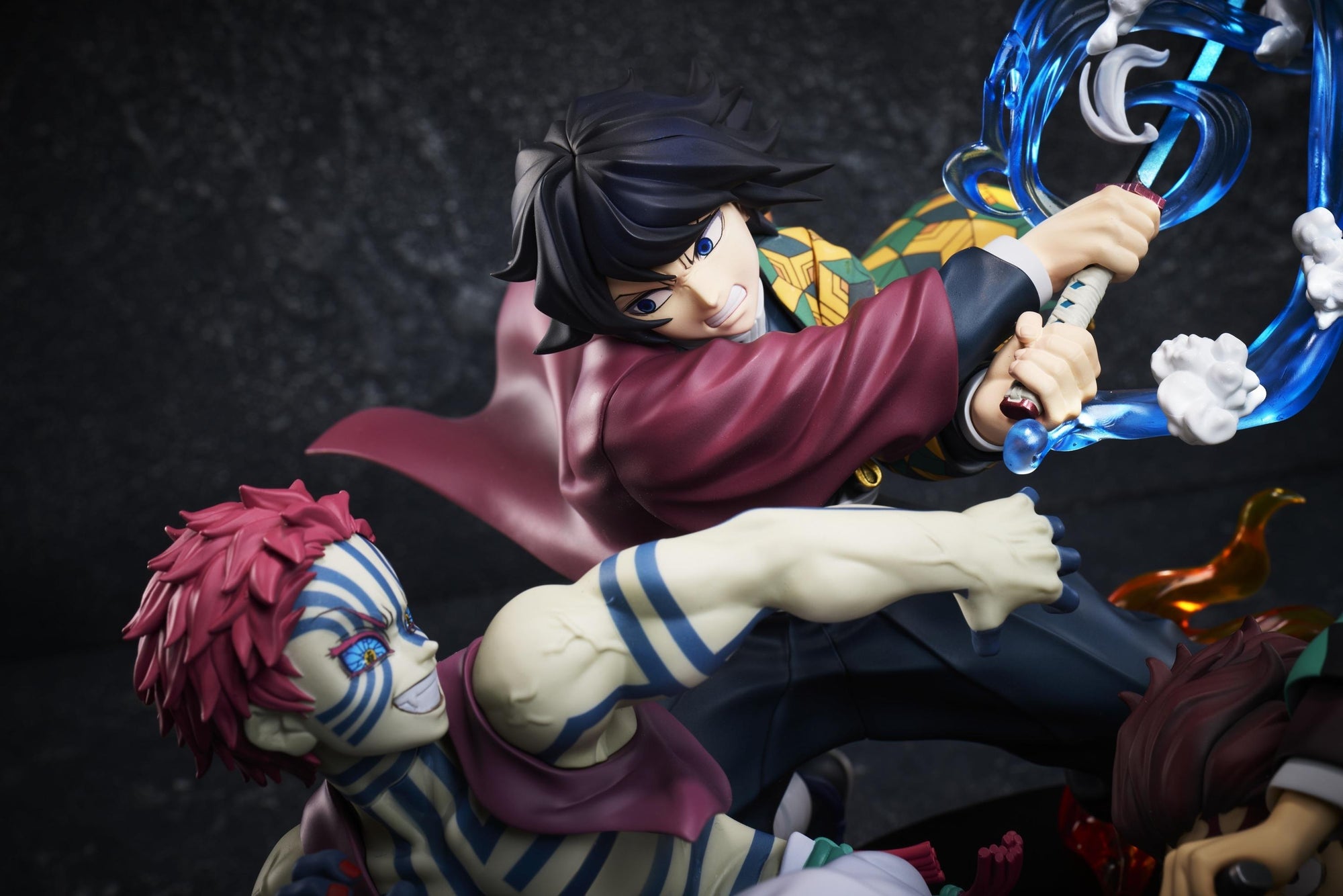 Close-up shot of Giyu Tomioka wielding his Water Breathing Nichirin sword alongside Akaza in the Aniplex battle figure