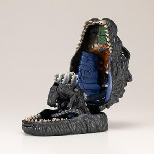 Opened Godzilla pocket playset revealing city backdrop and Godzilla figure from behind.