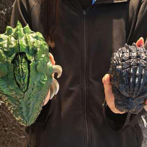 Closed Biollante and Godzilla pocket toys held in hands to illustrate product scale.