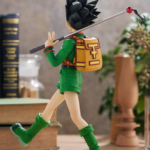 Back view of the Gon Freecss collectible figure within a rustic room diorama setting, highlighting his signature walking pose and yellow pack.