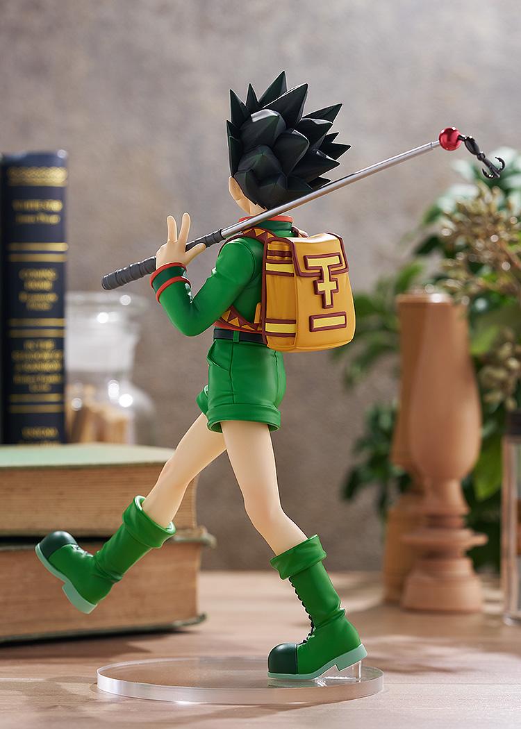 Back view of the Gon Freecss collectible figure within a rustic room diorama setting, highlighting his signature walking pose and yellow pack.