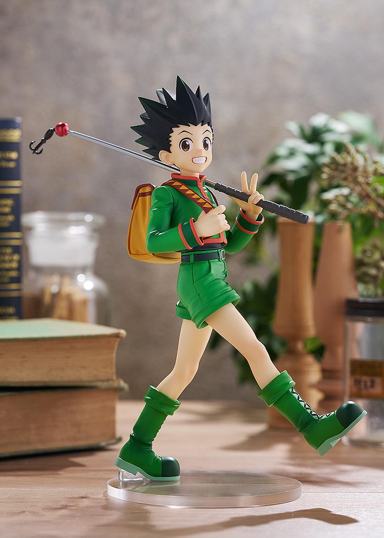 Full-body display of the L size Gon Freecss figure positioned within a warm, rustic study diorama backdrop alongside vintage books and ambient plants.