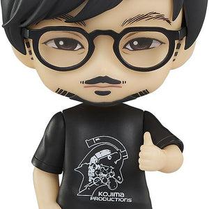 Studio cutout of Good Smile Company Hideo Kojima Nendoroid figure in logo t-shirt and glasses isolated on a white background.