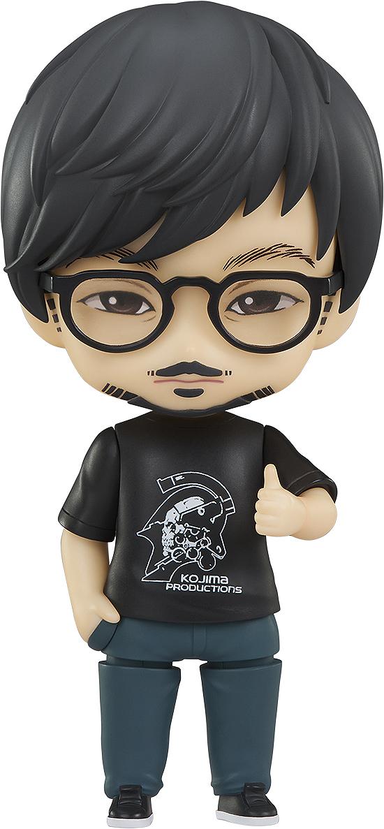 Studio cutout of Good Smile Company Hideo Kojima Nendoroid figure in logo t-shirt and glasses isolated on a white background.