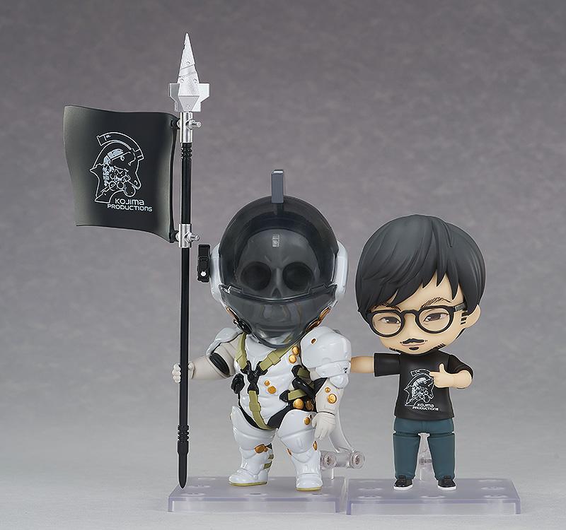 Hideo Kojima Nendoroid figure posed alongside Kojima Productions mascot Nendoroid Ludens holding a company logo spear flag.
