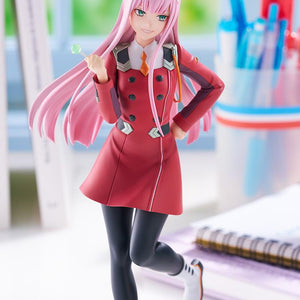 Close-up lifestyle promotional photo focusing on Zero Two's upper body, uniform detailing, and smiling expression on a desk setup.