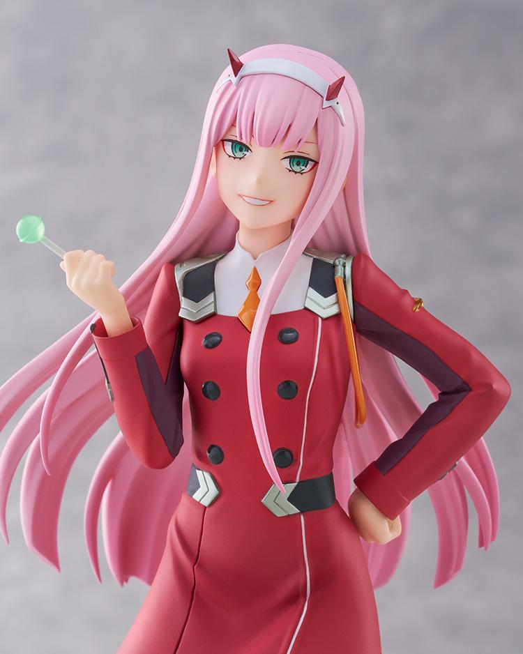 Close-up portrait of Zero Two showcasing her mischievous smile, red horns, green eyes, and lollipop from Darling in the Franxx.