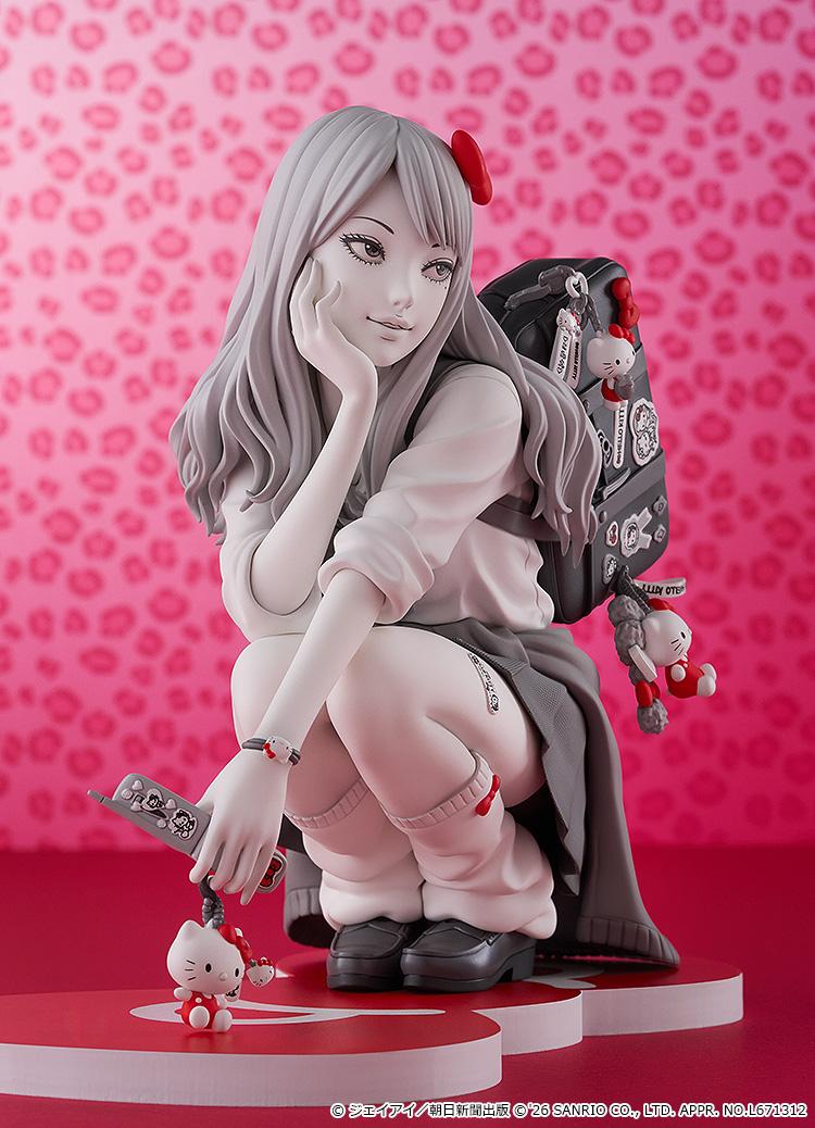 Vertical promotional shot of the Gyaru Tomie figure holding her decorated flip phone next to a pink leopard backdrop.