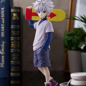 The Killua Zoldyck figure displayed casually, with the skateboard on his shoulder, posed next to books and plants.
