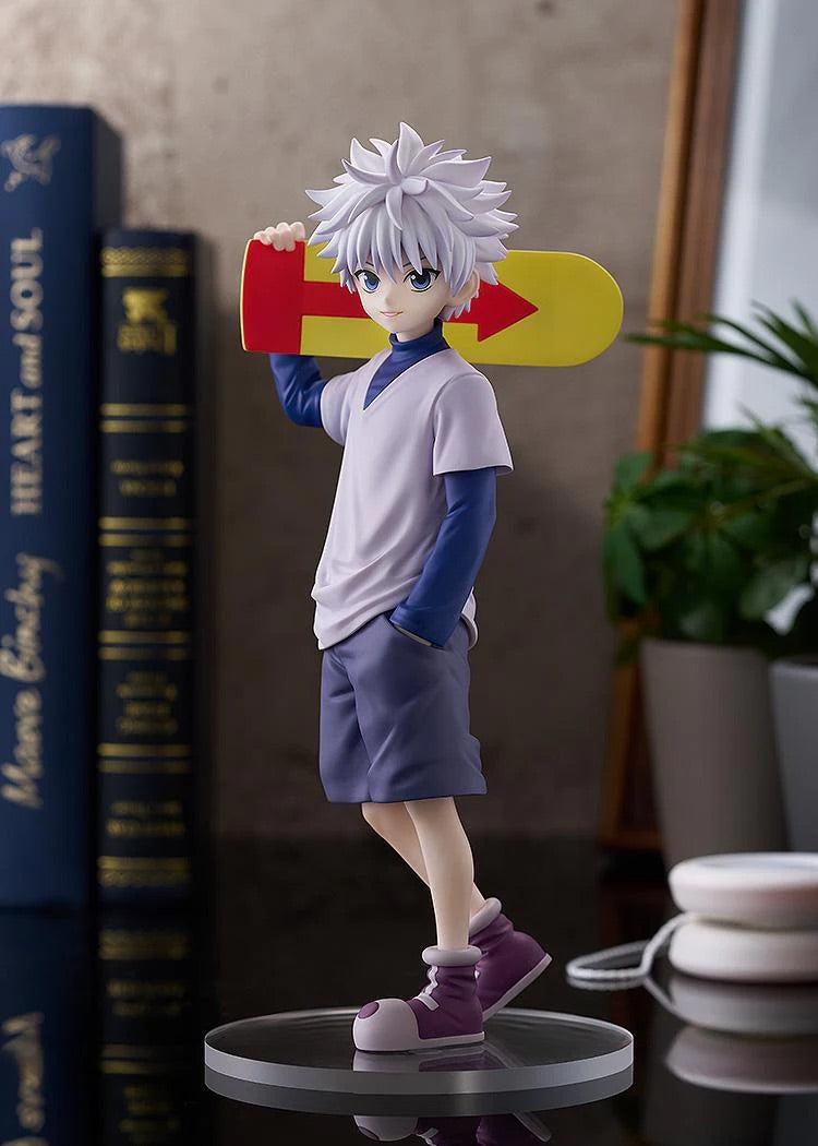 The Killua Zoldyck figure displayed casually, with the skateboard on his shoulder, posed next to books and plants.