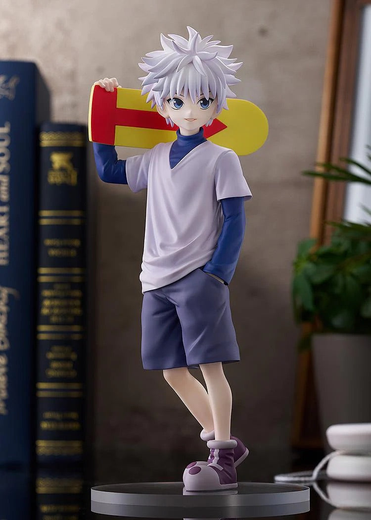 Full view of the Killua Zoldyck figure, showing the dynamic lean of his pose and the display setting with books.