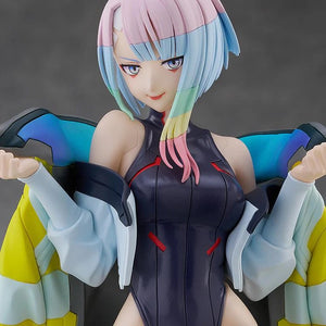 An extreme close-up portrait of the Lucy figure, highlighting her confident smirk, pink/blue hair, and stylized eyes.