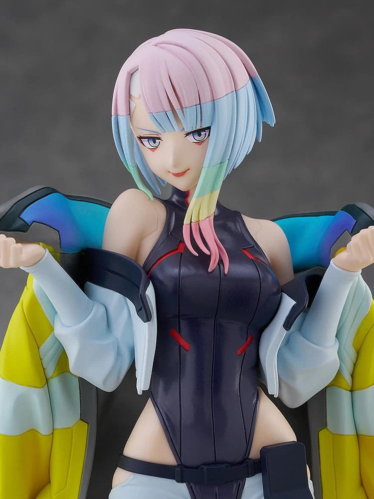 An extreme close-up portrait of the Lucy figure, highlighting her confident smirk, pink/blue hair, and stylized eyes.