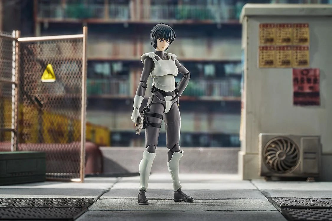 Motoko Kusanagi figure standing in a confident pose in a warehouse diorama, with her pistol holstered and a mild smile.