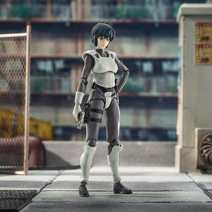Motoko Kusanagi figure standing in a confident pose in a warehouse diorama, with her pistol holstered and a mild smile.
