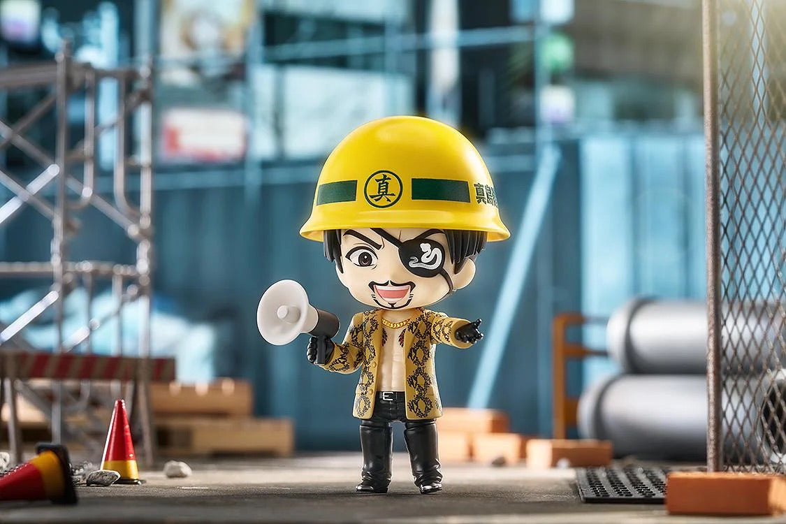 Majima Nendoroid figure wearing the construction helmet and holding the megaphone, set in a construction site diorama.