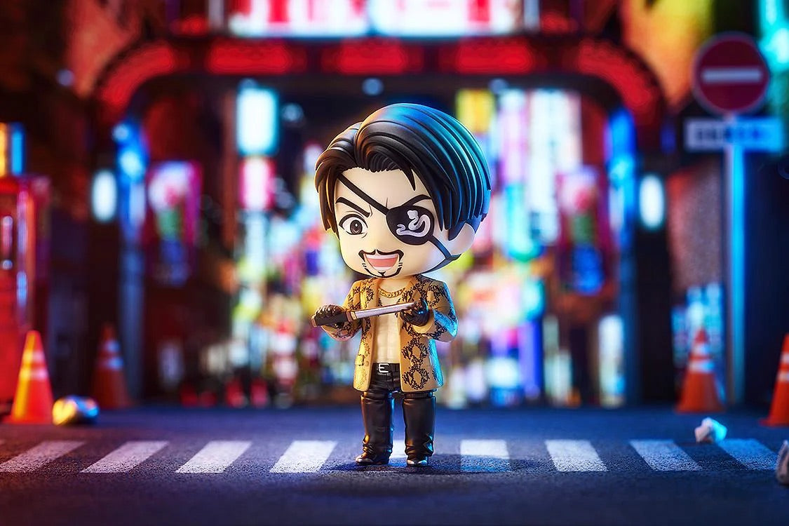 Majima Nendoroid figure standing in a brightly lit street diorama, preparing for combat with a small dagger in hand.