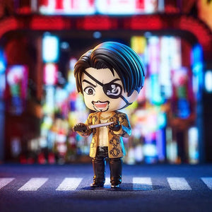 Majima Nendoroid figure standing in a brightly lit street diorama, preparing for combat with a small dagger in hand.